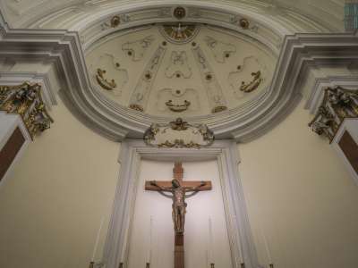 ..., sopra cui troneggia il monumentale Crocifisso in bronzo. Sulla cattedra si apre la volta della cupola decorata a stucchi